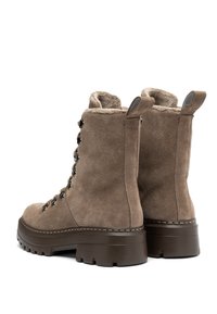 Botas de invierno de ante topo con forro de lana, ganchos negros para los cordones, suelas gruesas de goma marrón y tiradores en la parte posterior.