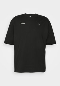 T-shirt noir à manches courtes avec les logos blancs "G-STAR" et "RAW" sur la partie avant de la poitrine, présenté sur un fond blanc uni.
