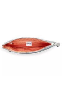 Kipling pouch lavet af lys grå stof med en glat tekstur, der har en orange foring og en sølvlynlås med en dekorativ trækflap.