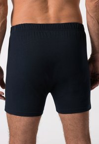 Černé bavlněné boxerky s elastickým pasem. Materiál je hladký a pružný, navržený pro přiléhavý vzhled.