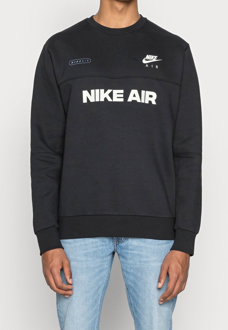 Svart sweatshirt med rund hals, prydd med "NIKE AIR" i vit text och logotypdetaljer. Mjukt tyg med ribbade ärmslut och nederkant.
