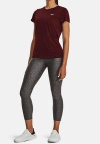 Bourgogne kortærmet atletik t-shirt med rund hals; kombineret med grå teksturerede leggings og hvide sportssko.