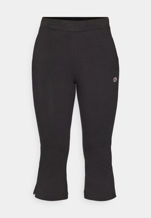 Pantaloni da jogging Capri neri realizzati in materiale morbido, con una vita aderente e fenditure laterali all'orlo. Presentano un piccolo logo sulla gamba inferiore.