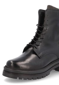 Botte noire en cuir à lacets avec un bout arrondi, une tige texturée, une semelle robuste avec un motif cranté, et des œillets métalliques pour les lacets.