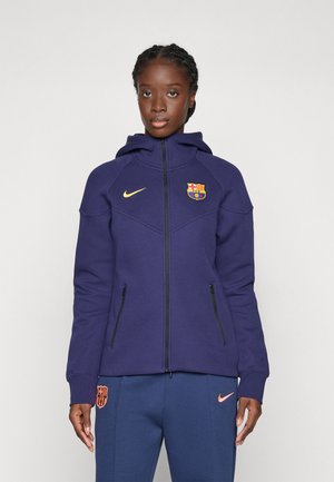 Lila zip-up hoodie med huva, prydd med Barcelonas emblem och Nike-logotyp i guld. Texturerad tyg och två sidfickor med dragkedja.