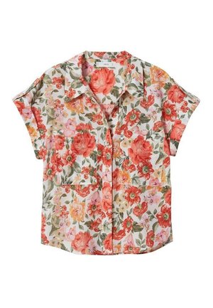 Kvinde iført kortærmet blomstret skjorte åben over hvid bandeau-top, højtaljede blå denimshorts med bælte og sorte åbne hælede sandaler.