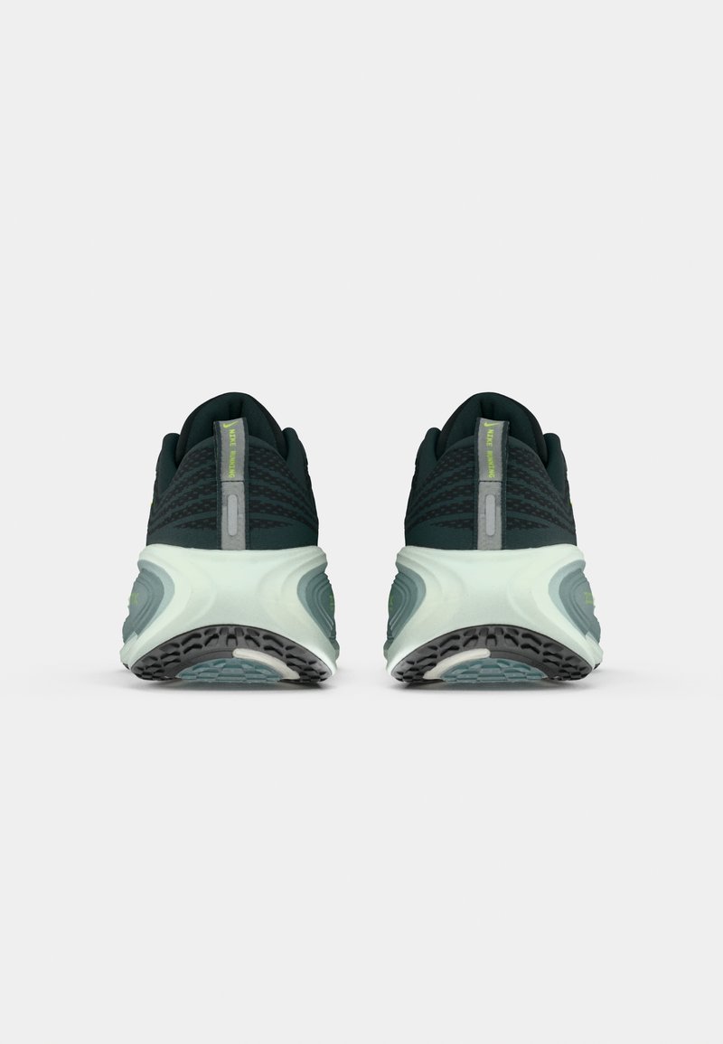 Par de zapatillas de correr negras y verde claro, vistas desde atrás, con suelas texturizadas y lengüetas etiquetadas como "Nike Running."