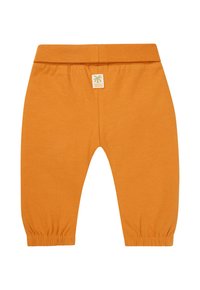 Orangenfarbene Baumwollhosen mit einem elastischen Bund, gerafften Bündchen und einem kleinen Etikett mit einem Palmen-Design. Glatte Textur.