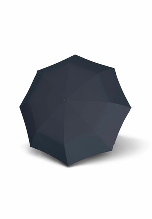 Black fully opened umbrella viewed from above casting a shadow on a white surface.