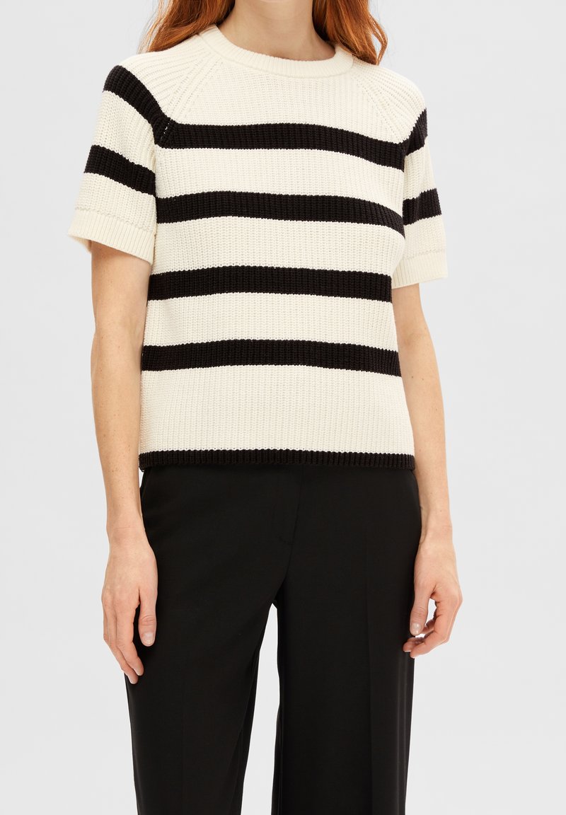 Strikket kortærmet sweater med sorte og hvide vandrette striber, rund halsudskæring samt ribkanter ved nederste kant og ærmer.