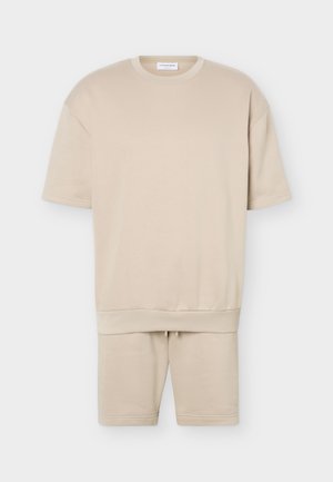 Beige sweatshirt met korte mouwen en ronde hals en bijpassende korte broek met geribde boorden en een tunnelkoord in de taille van de korte broek.