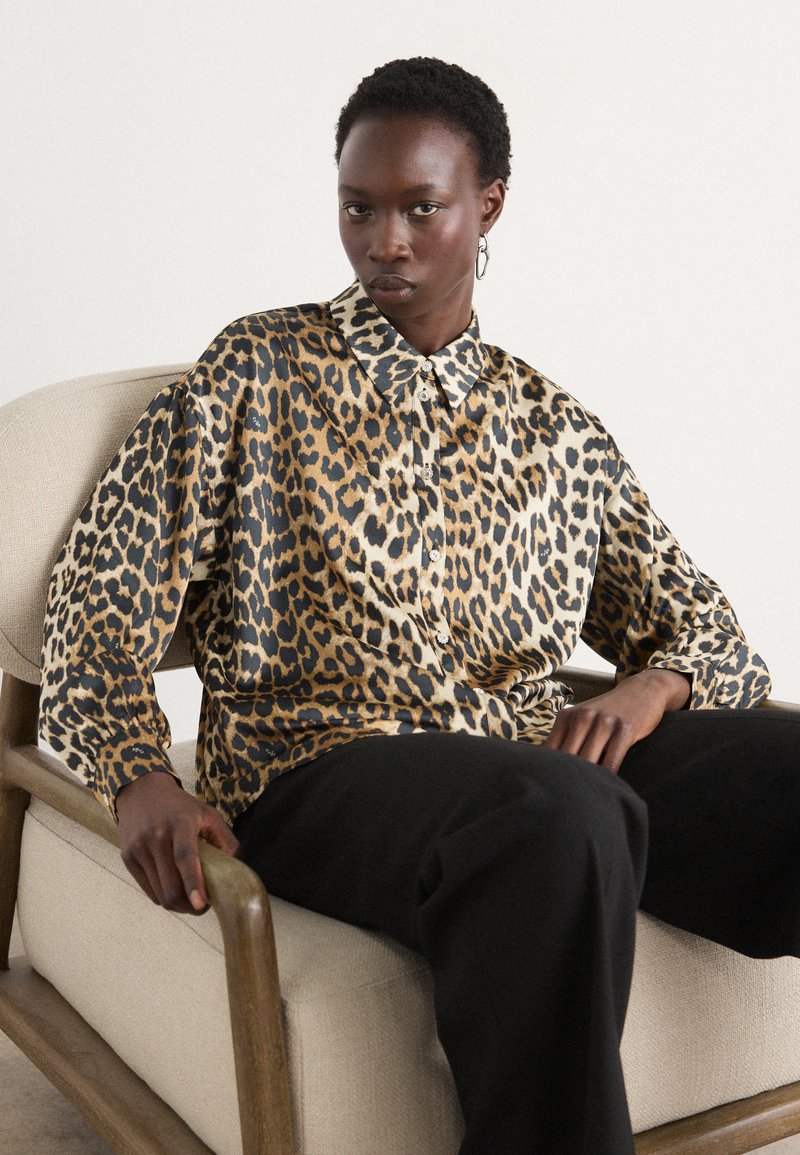 Leopardmønstret skjorte i silke blande, med klassisk krave og knappelukning, lange ærmer og løs pasform. Båret med sorte bukser.