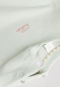 Pull vert menthe avec col côtelé, doté d'une texture douce. Logo rose brodé et détail bouton-pression sur un côté.