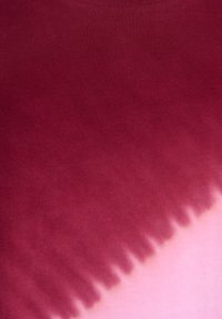 Raudonas ir rožinis tvido audinys su glotnia tekstūra, turintis gradientinį perėjimą nuo burgundijos iki šviesiai rožinės, su aštriais, nelygiais kraštais.