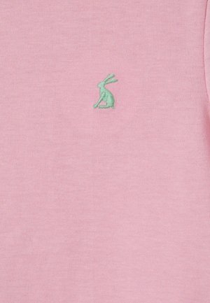 Grünes gesticktes Hasenlogo, mittig auf hellrosa Stoffhintergrund platziert.