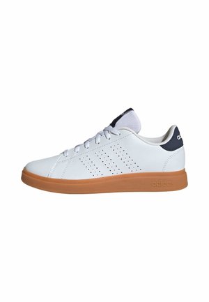 Zapatilla deportiva blanca con parte superior de cuero suave, detalles perforados, cuello acolchado y suela de goma. Presenta cordones de color gris claro.
