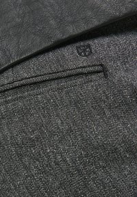 Must mustriga nahk ülevõtt hallal denim kangal. Omab väikest tikitud logo ja õrna õmblusdetaili.