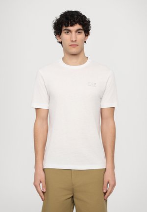 Witte katoenen T-shirt met ronde hals, korte mouwen en een subtiele EA7-logo in lichtgrijs op de linkerborst. Soepele textuur.