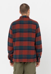 Rød og blå ternet flannel skjorte med krave, lange ærmer og knapfunktion på manchetterne. Blød tekstur med en afslappet pasform.