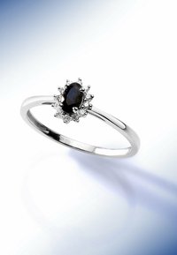 Silberring mit einem ovalen schwarzen Edelstein, umgeben von einem Halo aus kleinen klaren Steinen. Glatte, polierte Fassung mit schlankem Profil.