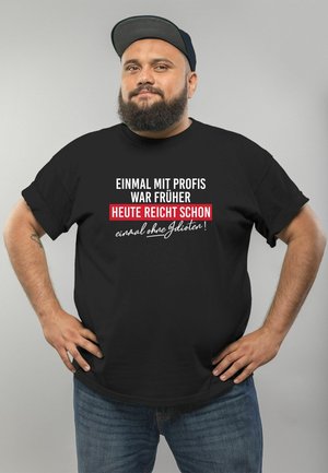 Black t-shirt with a round neckline featuring bold white and red text. The fabric appears soft and casual, suitable for everyday wear.