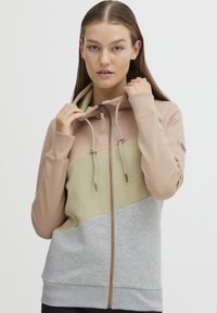 Hooded sweatshirt with a zip closure, featuring beige, olive green, and gray color blocks, constructed from soft cotton material.