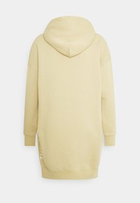 Robe à capuche jaune clair avec une capuche spacieuse, des manches longues et des fentes latérales. Fabriquée en tissu doux, avec un design minimaliste et un détail de texte blanc.