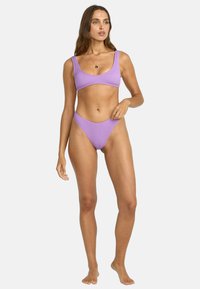 Lila ribbad bikiniuppsättning med kvadratisch nacke och högmidjade trosor, som visar en texturerad tyg och en sömlös design.
