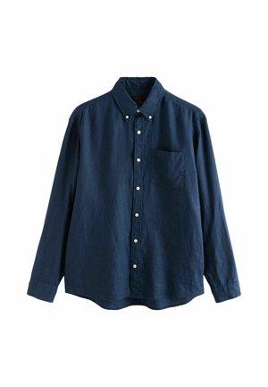 Back of a bald person's head wearing a dark blue shirt with a button at the center of the collar.