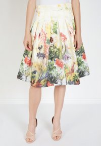 Falda floral con plisados, fabricada en tejido ligero. Presenta una mezcla de colores vibrantes que incluyen amarillo, rojo y verde. Bajo a la mitad de la pantorrilla.