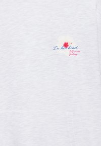 Tissu blanc avec petit imprimé floral et texte indiquant « Dans sa tête. Fantaisie faite maison » en lettres bleues et roses.