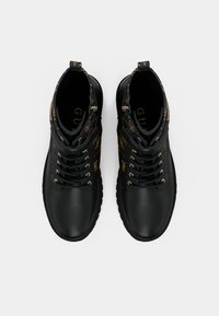 Bottes montantes noires avec des accents dorés, arbore un dessus en cuir lisse, un panneau texturé contrastant et des œillets métalliques pour les lacets.