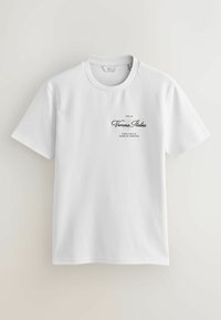 Camiseta de algodón blanca con cuello redondo y mangas cortas, con texto negro que dice: "Verona Italia" y "Región de Provincia de Veneto" impreso en el frontal.