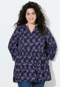 Black tunic featuring a floral pattern in purple and green, with a v-neck, long sleeves, and a gathered waist for a relaxed fit.