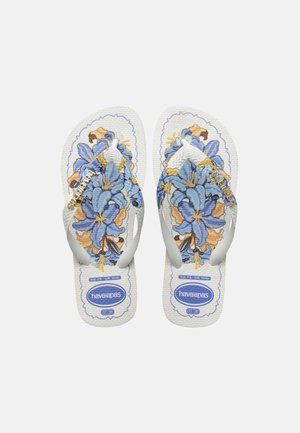 Białe klapki japonki z niebiesko-brązowymi kwiatowymi wzorami i białymi paskami, z oznaczeniami marki Havaianas i rozmiaru na podeszwach.