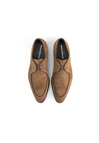 Bruine suède schoenen met een slank, puntig ontwerp. Voorzien van subtiele contrasterende stiksels en een vetersluiting. Merklocatie aan de binnenkant.