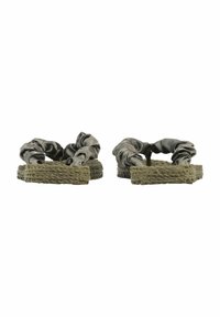 Sandalias de plataforma trenzadas en verde con correas de tela oscura arrugada y diseño de punta abierta; superficie texturizada y suelas planas.