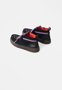 Μαύρες σουέτ παπούτσια με ροζ κορδόνια, κόκκινη εσωτερική επένδυση και αυλακωτές καουτσούκ σόλες. Διαθέτουν λογότυπο στο πλάι και μοναδικό σχέδιο με κοψίματα.