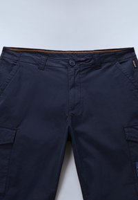 Pantalones cortos tipo cargo azul marino con cierre de botón, bolsillos frontales, presillas para cinturón y bolsillos laterales con solapa, dispuestos planos sobre un fondo claro.