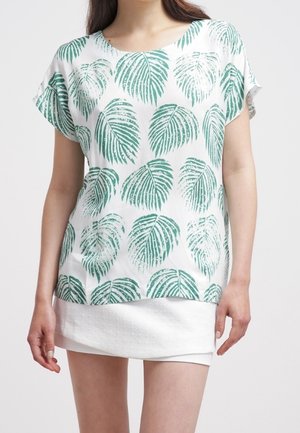 Top bianco con motivo di foglie tropicali verdi, maniche corte e scollatura rotonda. Tessuto morbido; stile a strati con parte inferiore bianca testurizzata.