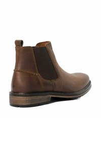 Brown leather Chelsea boot with elastic side panels, rounded toe, textured fabric accents, and a low stacked heel.