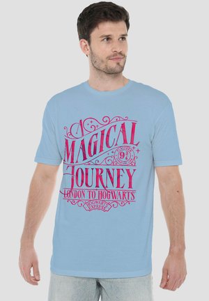 Mann trägt ein hellblaues T-Shirt mit rotem Text "A Magical Journey London to Hogwarts" und Platform 9 3/4 Hogwarts Express Design.