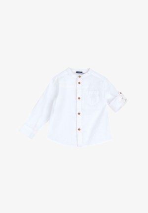 Camisa blanca de manga larga en tejido ligero con cuello redondo, cierre frontal de botones y un bolsillo en el pecho. Los puños abotonados están remangados.