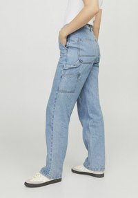 Pantalones cargo de mezclilla azul claro con un corte relajado, que presentan bolsillos laterales, bolsillos traseros con parche y un diseño de pierna recta.