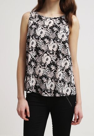 Blouse sans manches noire avec un motif floral blanc. Tissu léger, coupe ample, encolure ronde et ourlet légèrement arrondi.