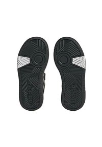 Czarne podeszwie butów Adidas z teksturowanej gumy, trójkątnymi wzorami i białymi akcentami. Posiada okrągłe strefy uchwytu oraz logo marki.