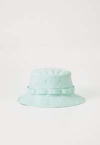 Sombrero tipo bucket de color verde menta claro fabricado en tela, con una banda alrededor de la base y agujeros de ventilación para mayor transpirabilidad. Diseño de ala ancha.