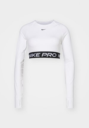 Hvit langermet topp med rund hals. Har et sort NIKE PRO-merket elastisk bånd i midjen og glatt, elastisk stoff.