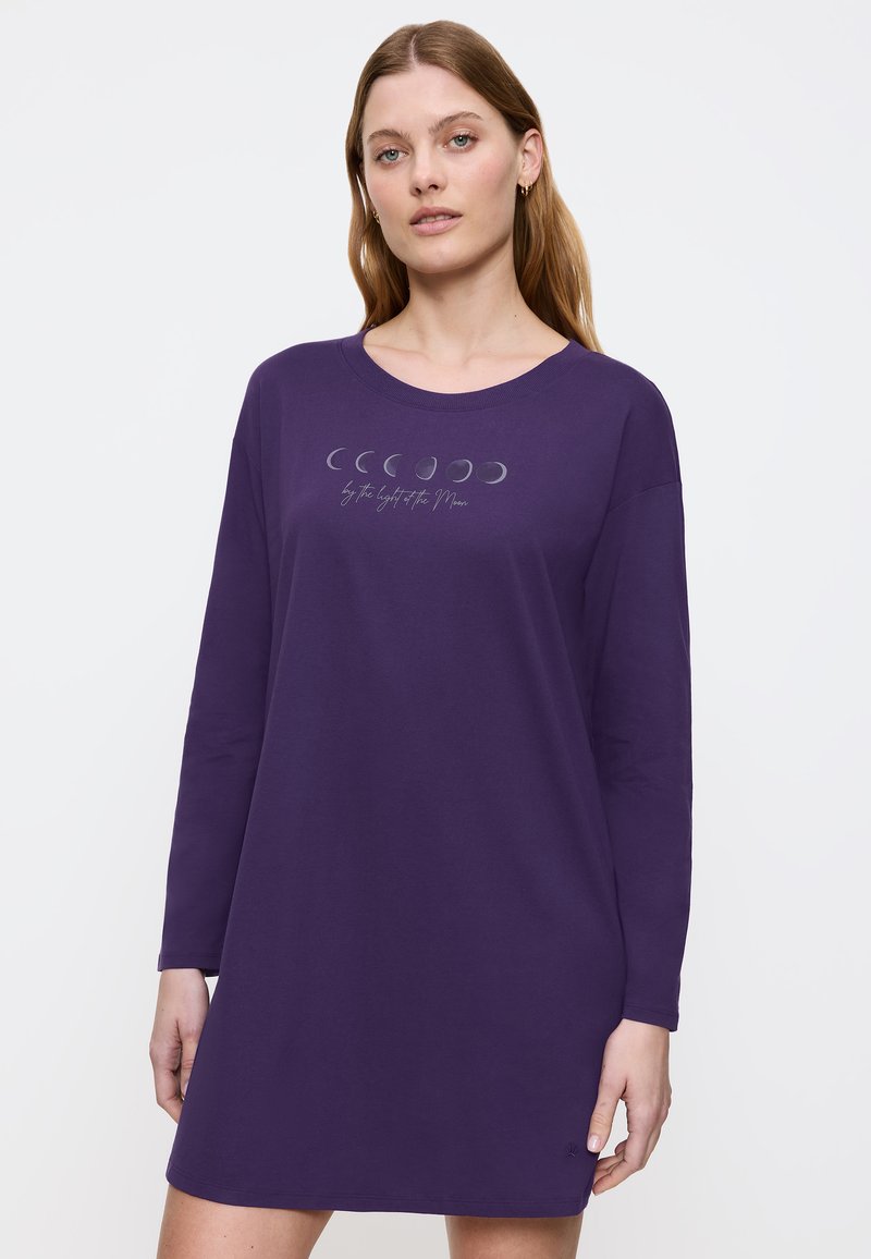 Fioletowa sukienka z długim rękawem, wykonana z miękkiego materiału, z graficznym motywem fazy księżyca i tekstem na klatce piersiowej. Casualowy, luźny krój.