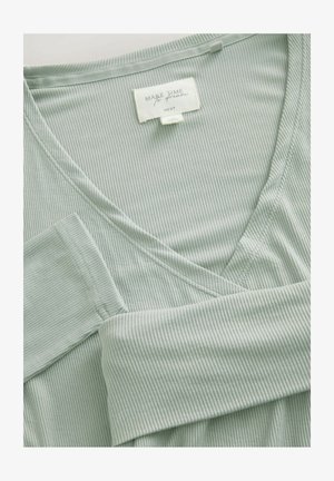 Tessuto verde chiaro, texturizzato, con design a V e cuciture visibili. L'etichetta recita "FAI TEMPO PER SOGNARE" del marchio "NEXT."